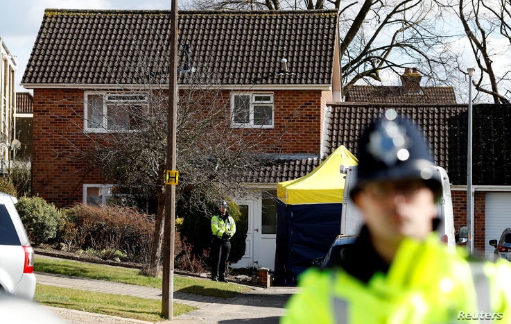Police officers stand guard outside the home of Sergei Skripal in Salisbury, Britain, March 8, 2018. 