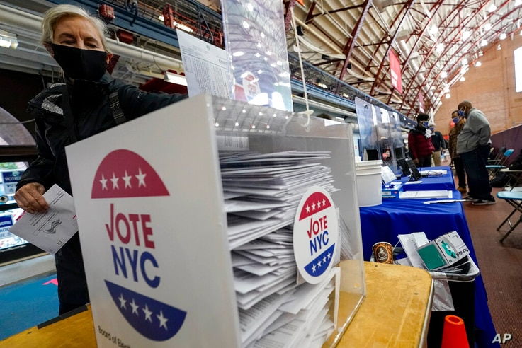A voter drops off her absentee ballot during early voting at the Park Slope Armory YMCA, Tuesday, Oct. 27, 2020, in the…