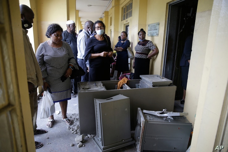 People inspect a damage safe at the federal high court building in Lagos, Nigeria, Oct. 26, 2020. 
