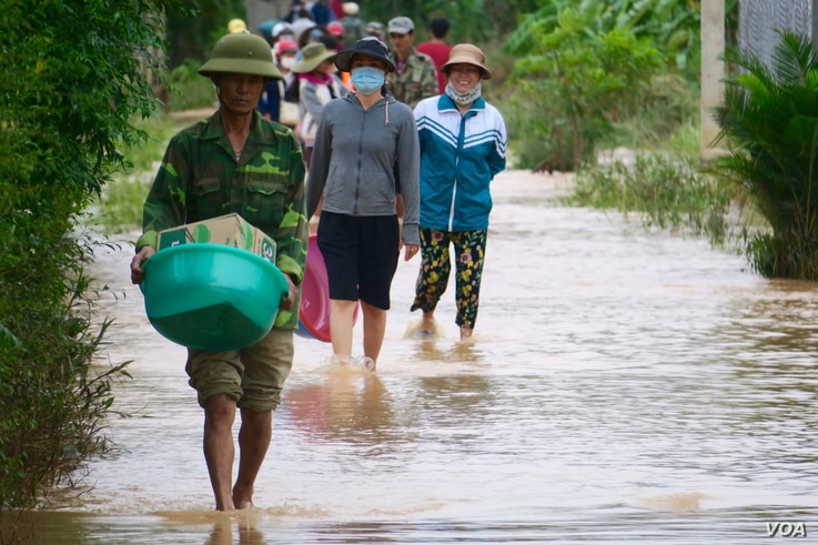 Locals walking through a flooded road in Quang Tri.