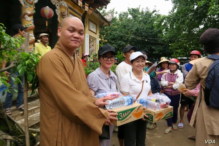 A monk hands out food supplies to locals in a pagoda in Quang Tri.