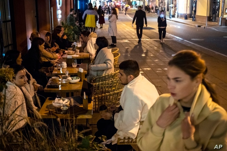 Customers sit outside a restaurant at Patriarshiye Prudy, a hip restaurant and bar district in Moscow, Russia, Oct. 16, 2020. 