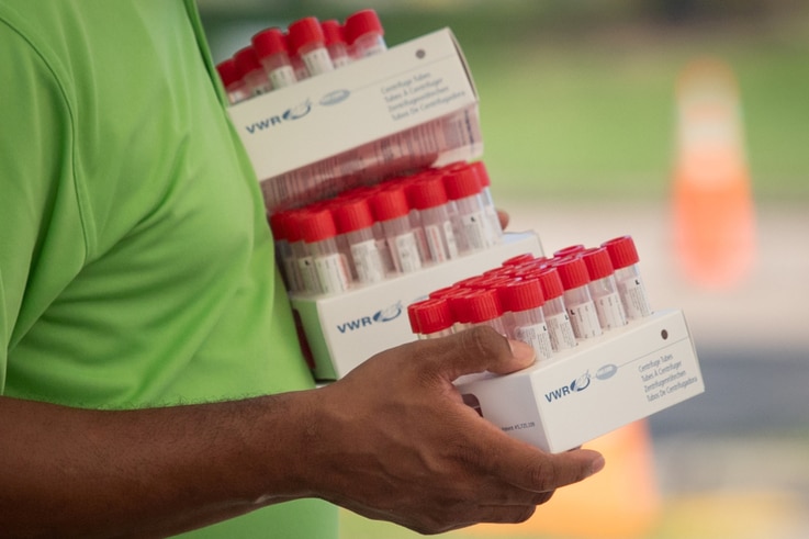 FILE PHOTO: Healthcare worker carries specimen collection tubes at COVID-19 drive-in testing location in Houston, Texas
