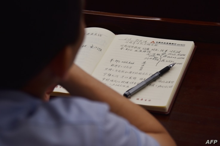 This photo taken on June 26, 2019 shows an adult student taking notes on Xi Jinping thought in a class at the Party School of…