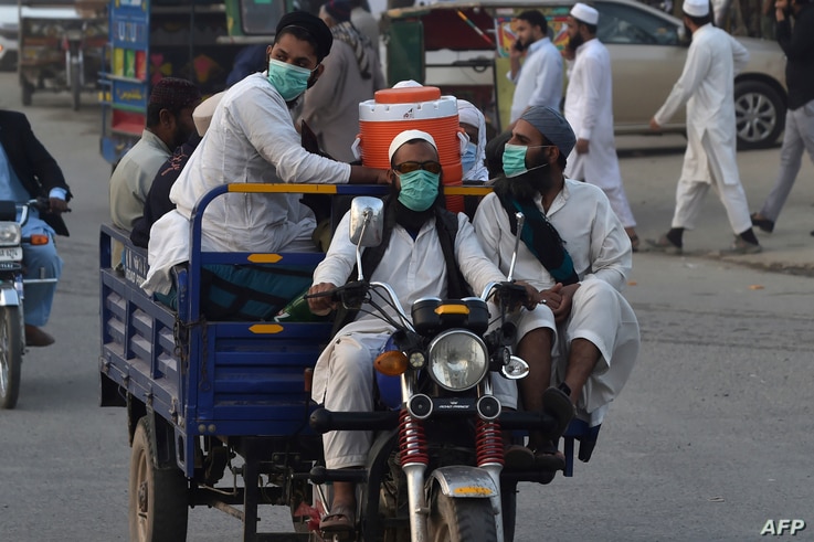 Pakistani Muslims wearing facemasks as a preventive measure against the Covid-19 coronavirus arrive for the annual Tablighi…