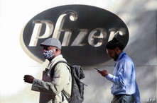 People walk by the Pfizer world headquarters in New York on November 9, 2020. - Pfizer stock surged higher on November 9, 2020…