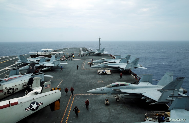 FILE - A-18 Hornet fighter jets and E-2D Hawkeye plane on the U.S. aircraft carrier John C. Stennis during joint military…