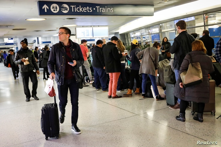 Travelers wait in the boarding area for trains during the Thanksgiving holiday travel rush at Pennsylvania Station in New York.
