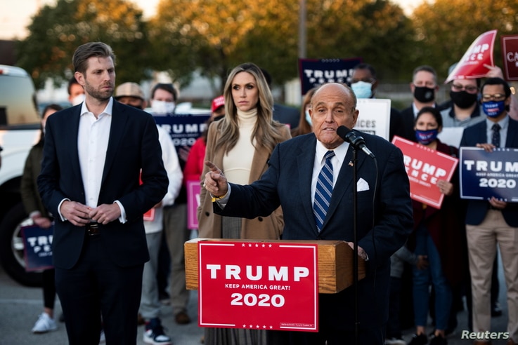 Former New York City Mayor Rudy Giuliani, personal attorney to U.S. President Donald Trump, speaks near Eric Trump and his wife.