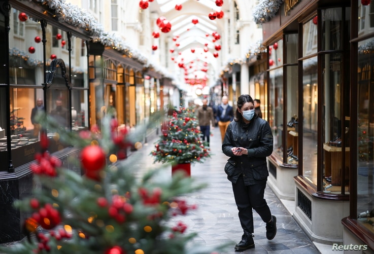 A woman walks through the Burlington Arcade adorned with Christmas decorations, amid the coronavirus disease (COVID-19)…