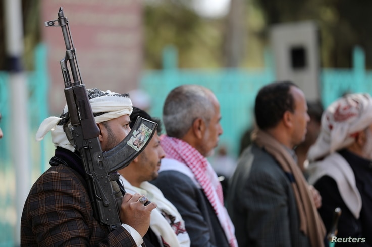 A Houthi supporter holds a rifle as he attends a ceremony held to send donated clothes to Houthi fighters at the frontlines…