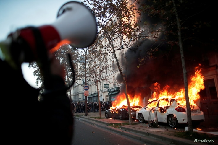 Cars burn during a demonstration against the 