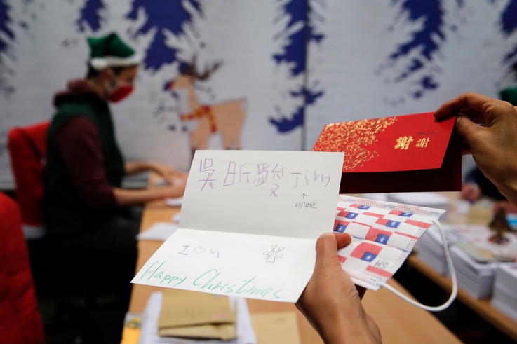 A postal worker shows an envelope from Jim of Taiwan, who sent a face mask inside the letter he sent and wrote 
