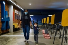 Lisa Carrera, a former Los Angeles Unified School history teacher from La Puente, Calif., holds the hand of her grandson.