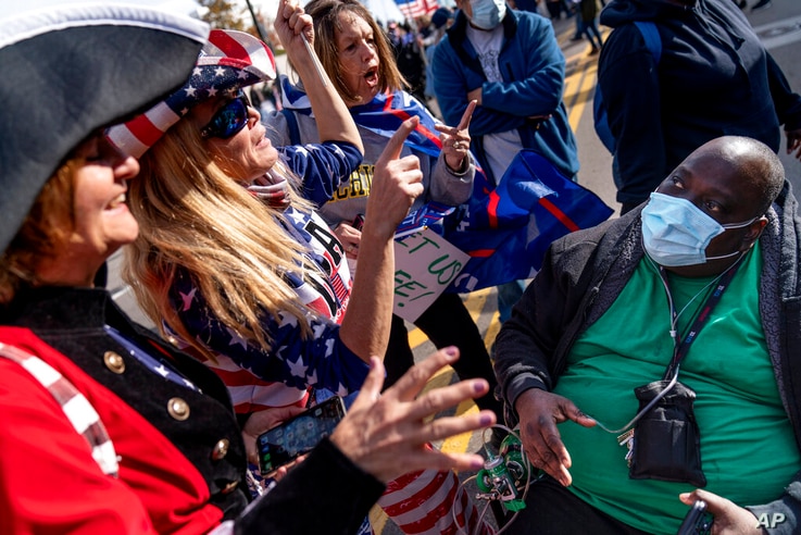A Biden supporter who would only give his first name, Douglas, right, engages in a debate with Trump supporters demonstrating…