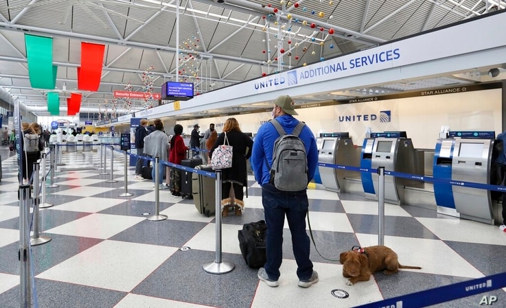 People wait in line at a United Airlines area in a terminal at O'Hare International Airport in Chicago on Friday, Nov. 20, 2020…