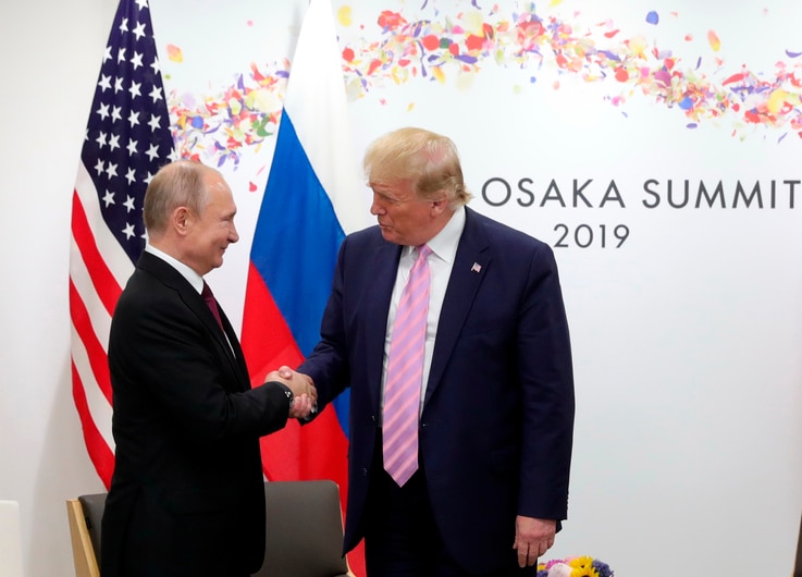 U.S. President Donald Trump, right, and Russian President Vladimir Putin greet each other during a bilateral meeting.