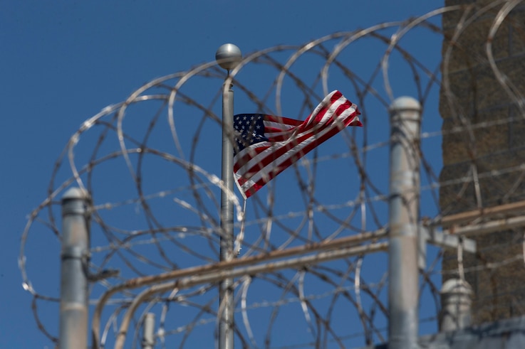 FILE - In this April 17, 2019 file photo reviewed by U.S. military officials, a U.S. flag flies inside the razor wire of the Camp VI detention facility in Guantanamo Bay Naval Base, Cuba. 