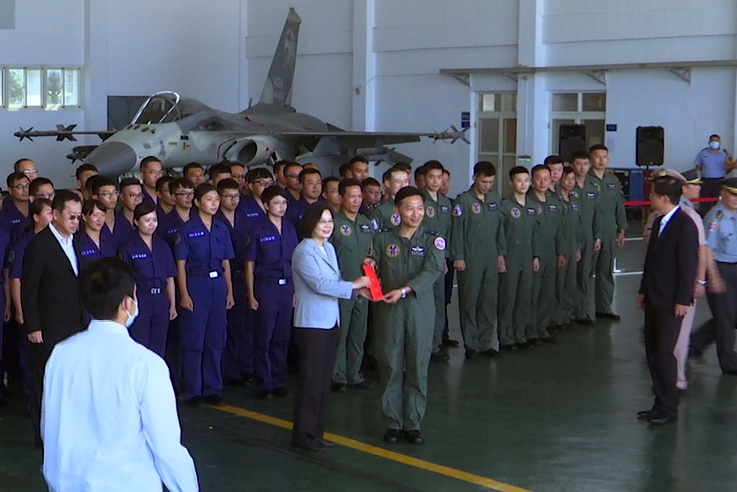 Taiwan President Tsai Ing-wen, center left, poses for photos with airmen near a Taiwan Indigenous Defense Fighter (IDF) jet…