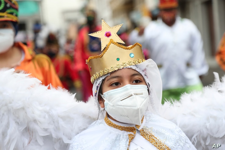 A child dressed as an angel character takes part in the Mama Negra festival in honor of the Virgin of Las Mercedes in Latacunga…