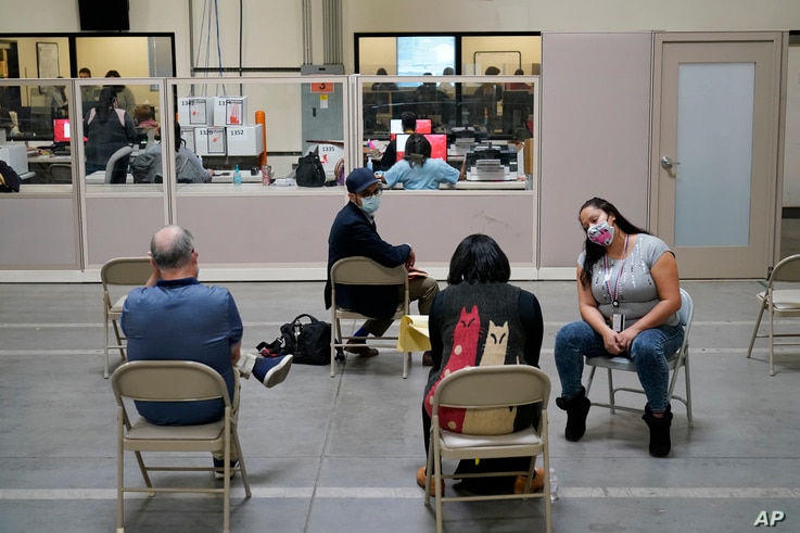 Observers watch as county election workers scan mail-in ballots at a tabulating area at the Clark County Election Department,…