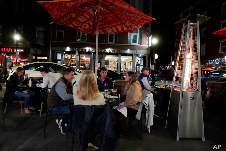 Diners have dinner outdoors, Friday, Nov. 6, 2020, in Boston's North End. More stringent coronavirus restrictions are now in…