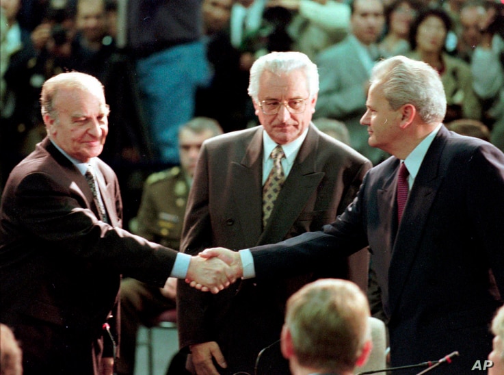 FILE - Bosnian President Alija Izetbegovic, left, shakes hands with Serbian President Slobodan Milosevic, right, as Croatian President Franjo Tudjman looks on, at Wright-Patterson Air Force Base in Dayton, Ohio, Nov. 1, 1995. 