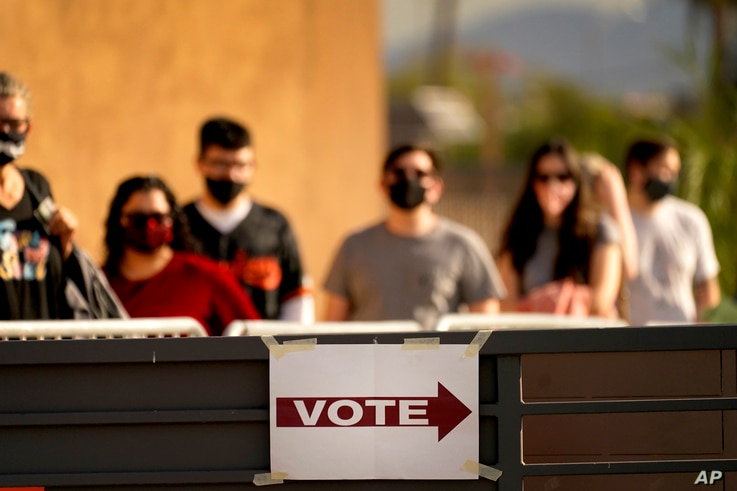 Voters stand in line outside a polling station on Election Day, in Mesa, Arizona, Nov. 3, 2020. 