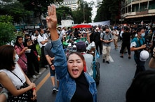 Pro-democracy demonstrators flash a three-finger salute of defiance during a protest rally in the Silom business district of…