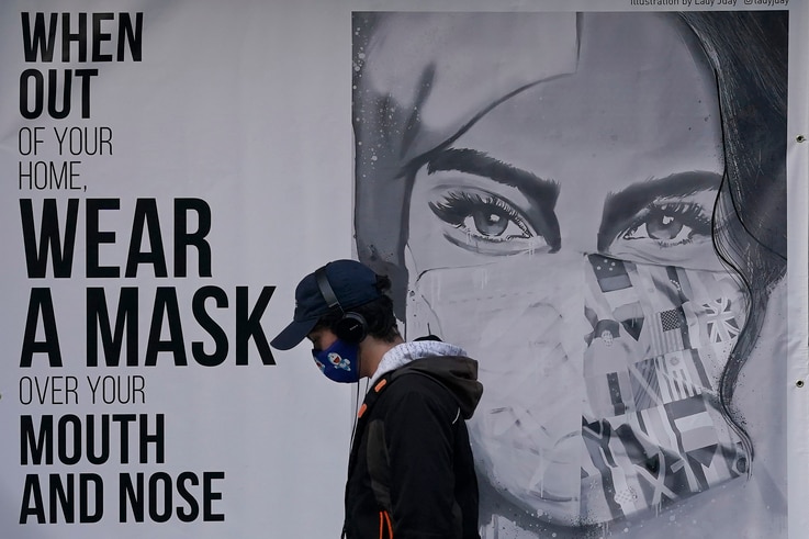 A pedestrian walks past a sign advising mask-wearing during the coronavirus outbreak in San Francisco, Saturday, Nov. 21, 2020…