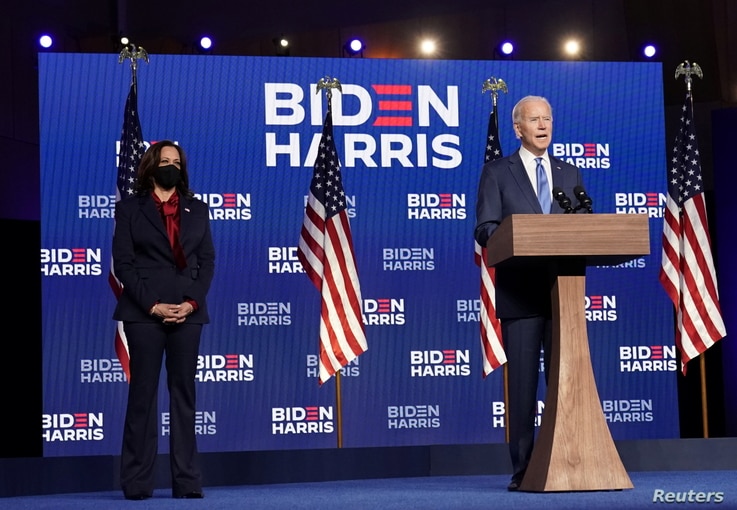 Democratic presidential candidate former Vice President Joe Biden speaks as his running mate, vice presidential candidate Senator Kamala Harris, left, looks on, in Wilmington, Delaware, Nov. 6, 2020.