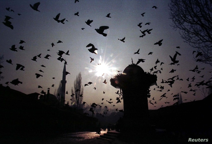 FILE - A flock of pigeons fly over Bascarsija square in the old part of Bosnia and Herzegovina's capital Sarajevo, Jan 11, 1998.