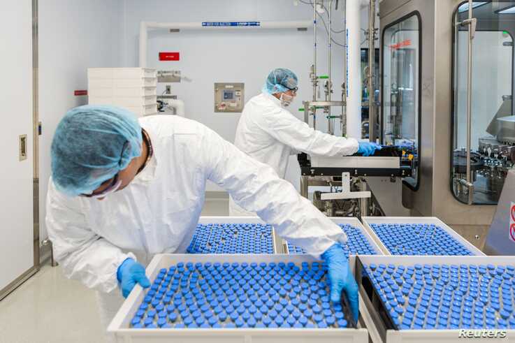 Lab technicians load vials of investigational coronavirus disease (COVID-19) treatment drug Remdesivir at a Gilead Sciences facility in La Verne, California, March 18, 2020. 
