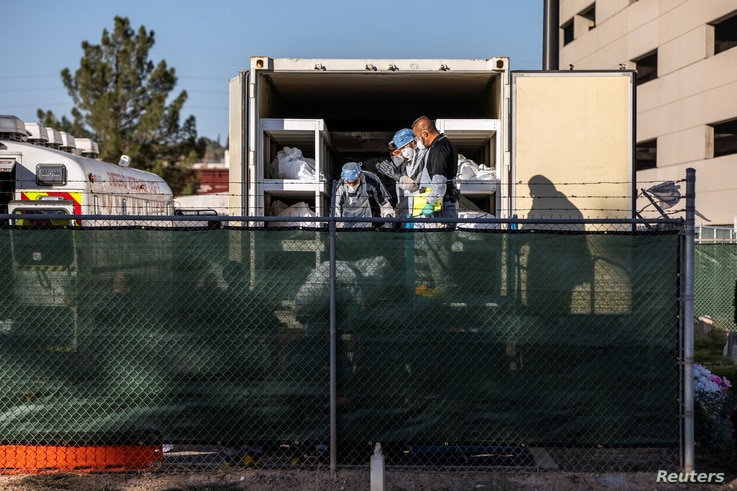 El Paso County detention inmates, Sheriff officers and morgue staff help move bodies to refrigerated trailers deployed during a surge of COVID-19 deaths, outside the Medical Examiner's Office in El Paso, Texas, Nov. 14, 2020. 