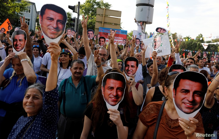 Supporters of Turkey's main pro-Kurdish Peoples' Democratic Party (HDP) hold masks of their jailed former leader and presidential candidate Selahattin Demirtas during a rally in Ankara, June 19, 2018.