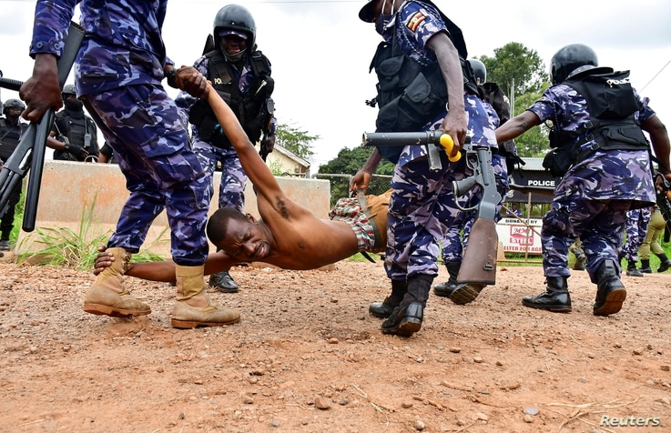 Riot policemen detain a supporter of presidential candidate Robert Kyagulanyi, also known as Bobi Wine, in Luuka district, eastern Uganda.