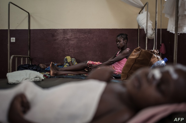A mother watches her HIV-positive child for observation in the intensive care unit of the Bangui pediatric complex, while in…