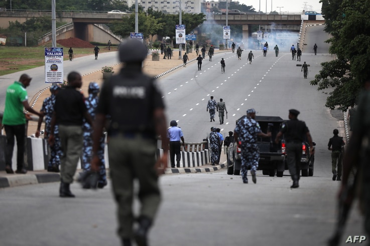 Nigerian police officers patrol in the streets of Abuja during clashes with members of the shiite Islamic Movement of Nigeria …