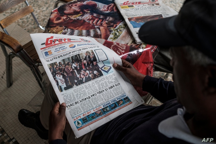 A man reads the Ethiopian Reporter newspaper with the cover showing  the Peace Nobel Prize ceremony for Ethiopia's Prime…