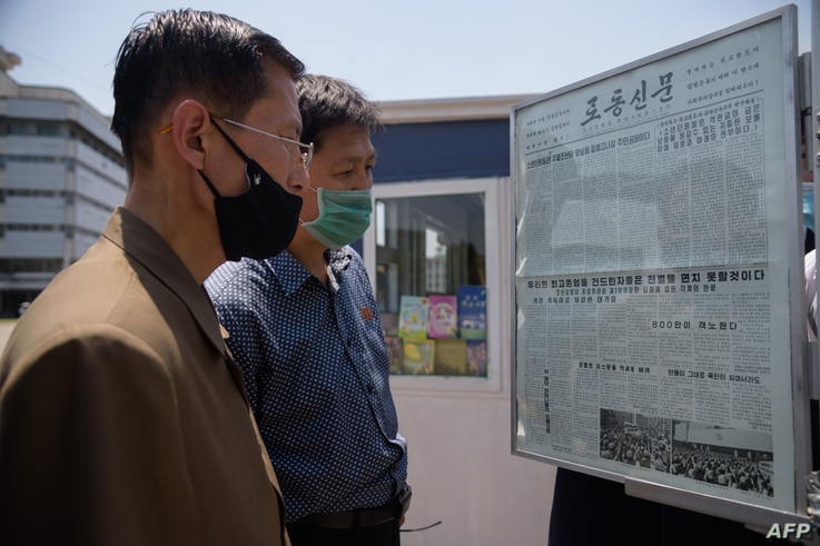 People read an article condemning anti-Pyongyang leaflets sent across the border by South Korean activists, at a news stand in…
