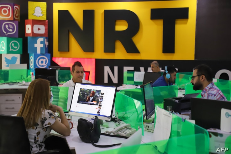 Journalists are pictured in the newsroom of Nalia Radio and Television (NRT) in Sulaimaniyah city, in the Kurdish autonomous…