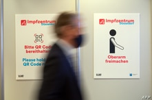 A person walks past pictograms on December 1, 2020 in the vaccination centre at the football stadium in Duesseldorf, western…