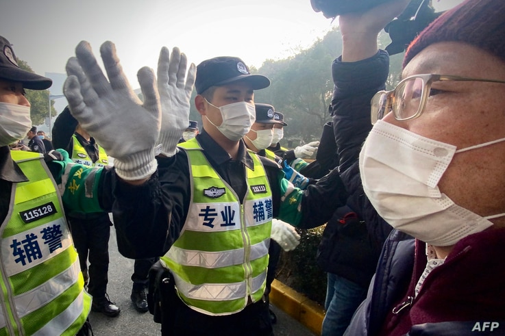 Police attempt to stop journalists from recording footage outside the Shanghai Pudong New District People's Court, where…