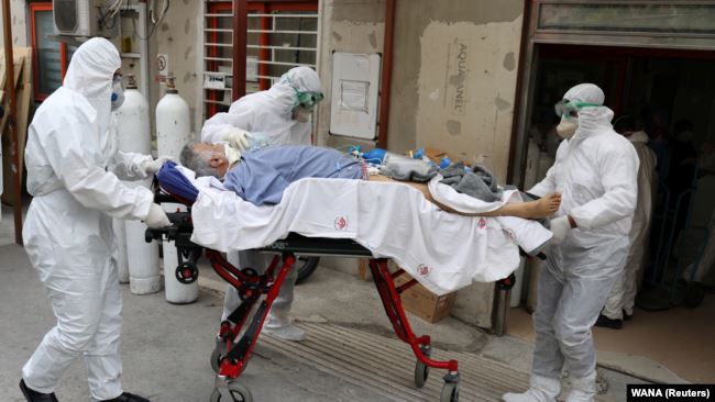 IRAN – Emergency medical staff transfer a patient with COVID-19 to Masih Daneshvari Hospital, in Tehran, on March 30, 2020.