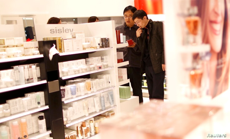 Men look at cosmetic products in a Duty Free store at the Fraport airport in Frankfurt Nov.4, 2012. Frankfurt airport's…