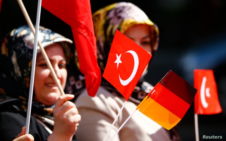 A Turkish woman waves a Turkish and a German flag during a demonstration including members of the Turkish ultra-nationalist…