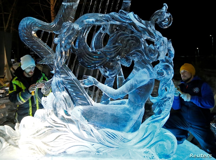 Artists from Russia's city of Yekaterinburg work on the ice sculpture 