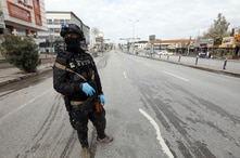 A security man stands in an empty street during a curfew imposed by Iraqi Kurdish authorities, following the outbreak of…