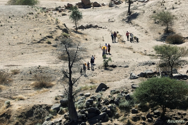 Ethiopians fleeing from the Tigray region walk towards a river to cross from Ethiopia to Sudan, near the Hamdeyat refugee…