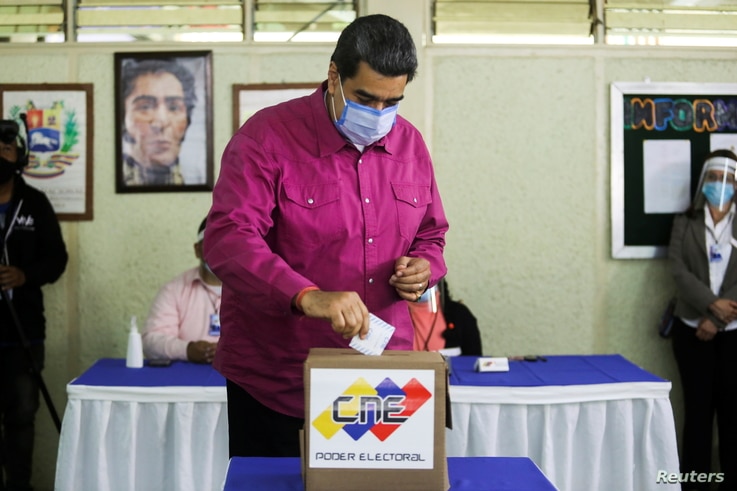 Venezuela's President Nicolas Maduro votes at a polling station during the parliamentary election in Caracas, Venezuela,…